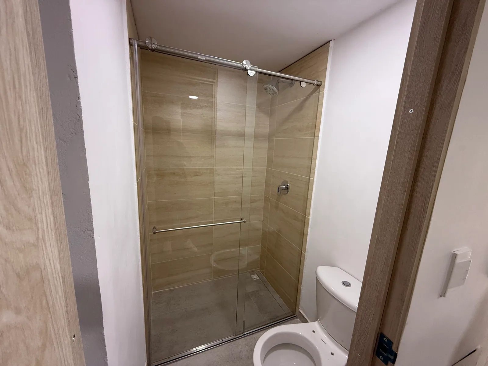 Baño auxiliar real del apartamento 806 con ducha en vidrio