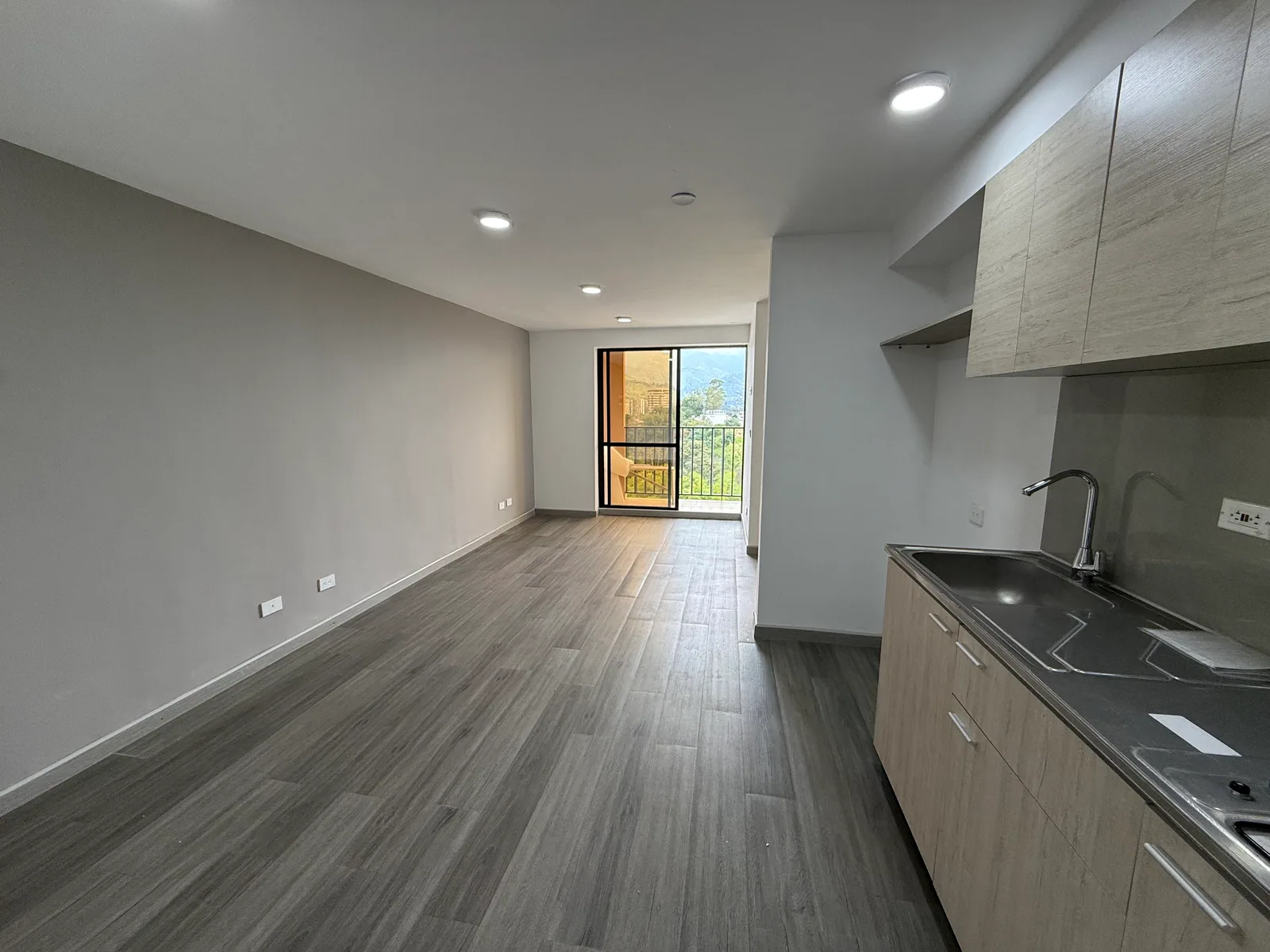 Sala-comedor y cocina reales del apartamento 806 vistos hacia el balcón