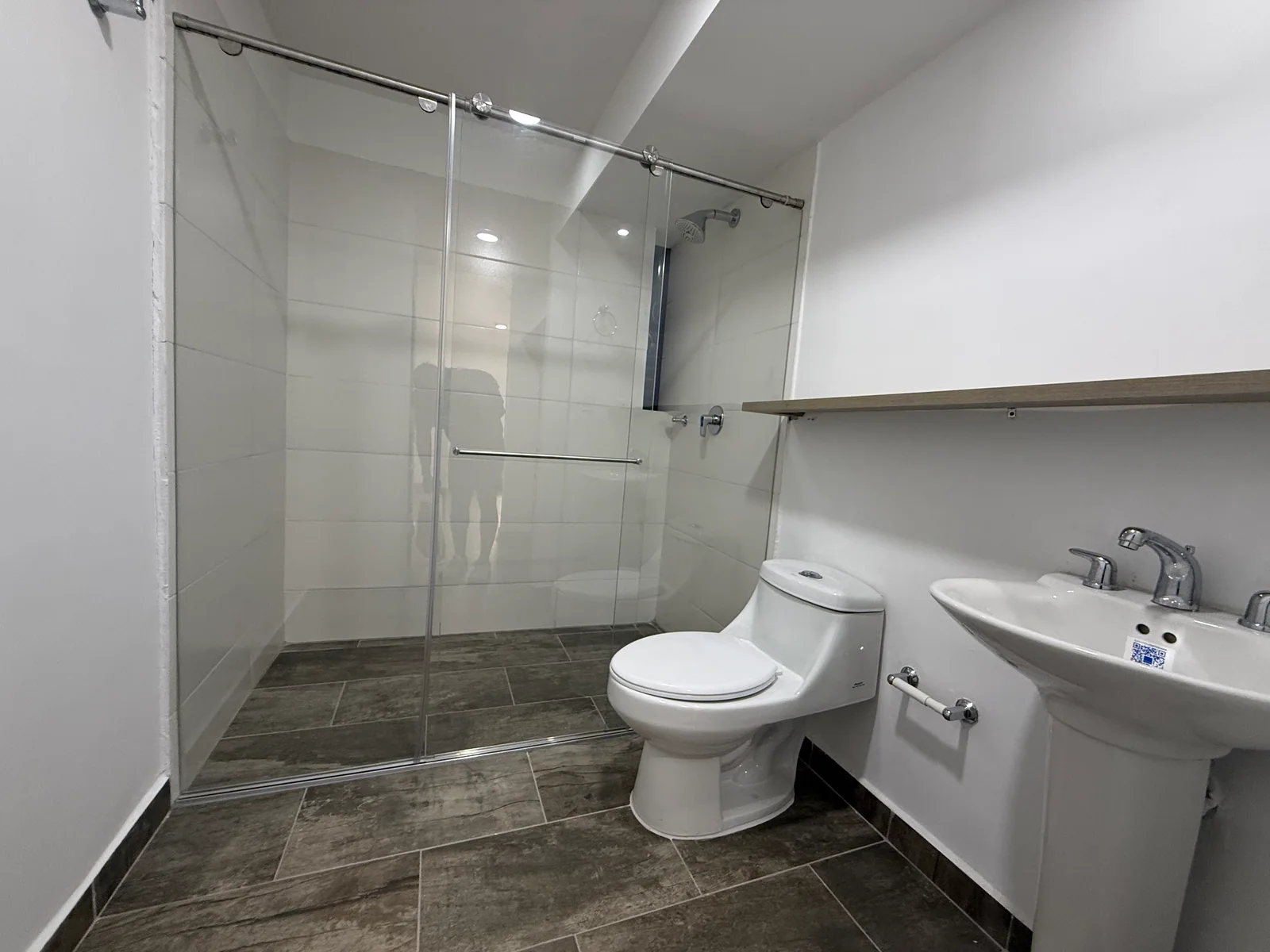 Baño principal completo del apartamento 806 con ducha en vidrio, sanitario y lavamanos
