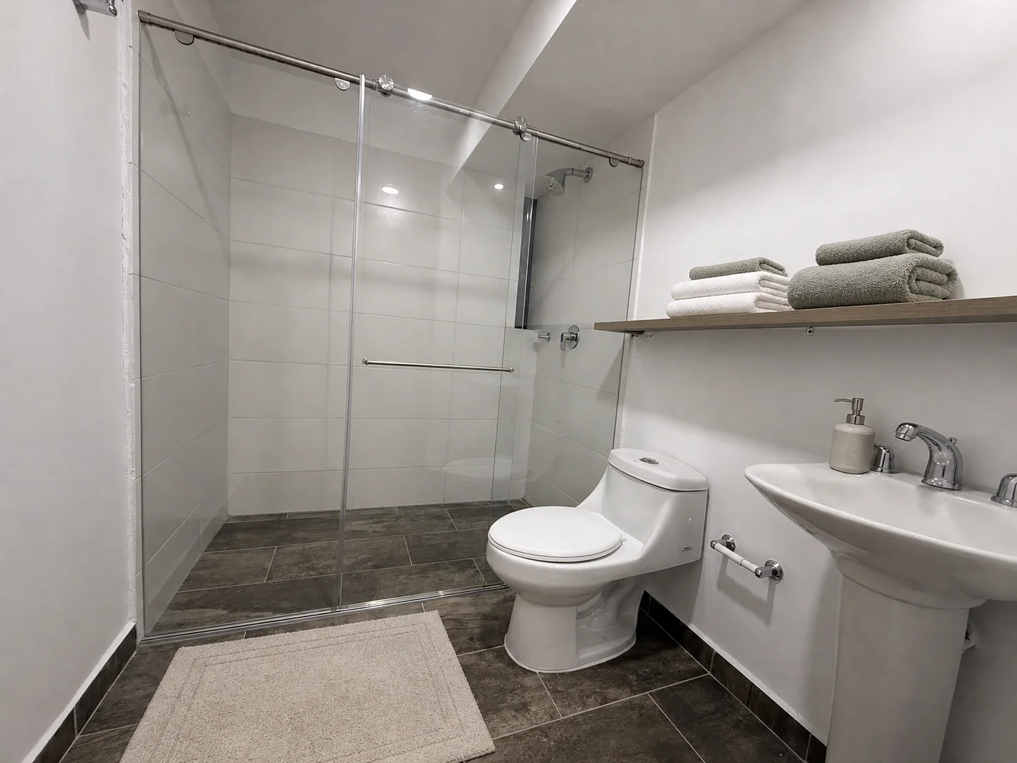 Baño principal del apartamento 806 acondicionado virtualmente con toallas, accesorios y tapete mediante inteligencia artificial